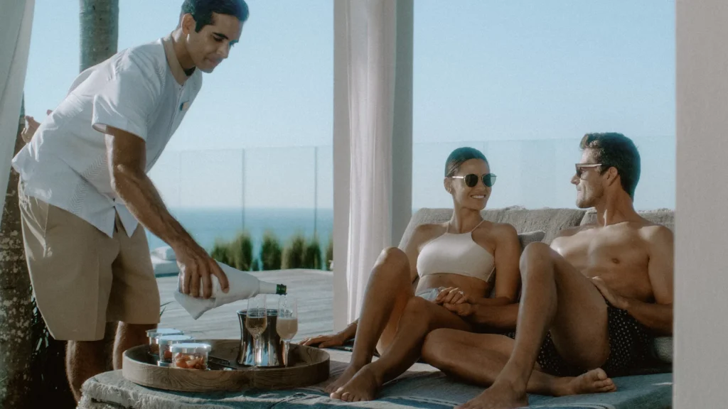 Butler serving champagne to a couple relaxing at a rooftop cabana at Impression Moxché by Secrets.