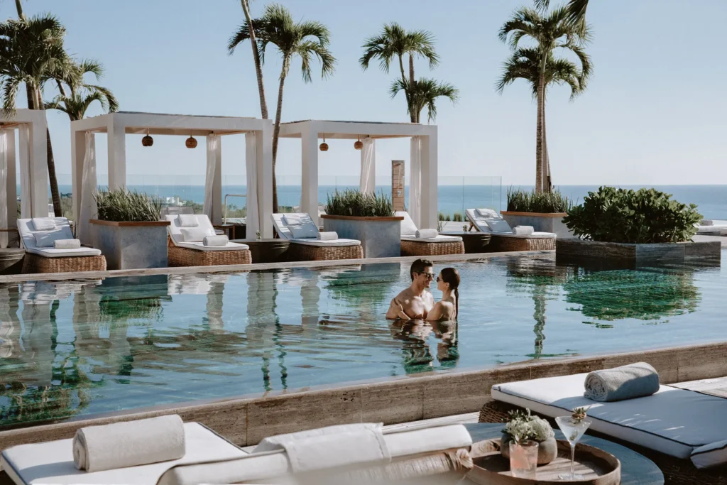 Couple relaxing in rooftop infinity pool overlooking the Caribbean at Impression Moxché by Secrets.