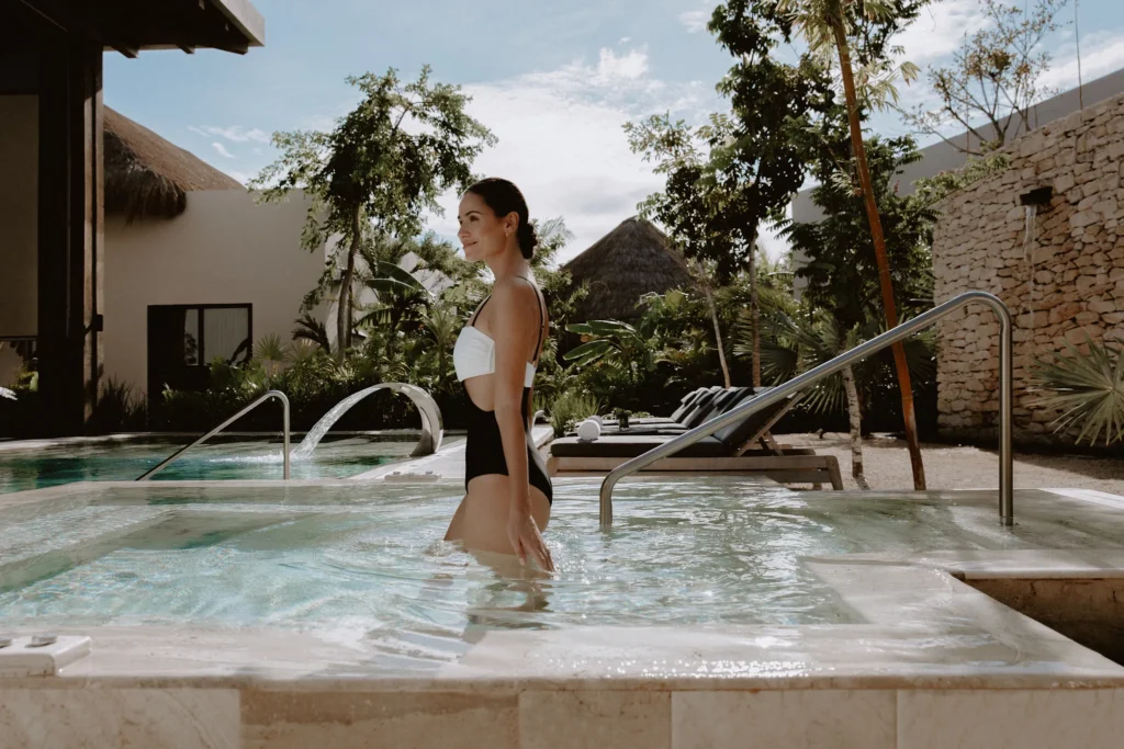 Woman relaxing in a hydrotherapy spa pool at Impression Moxché by Secrets in Riviera Maya.