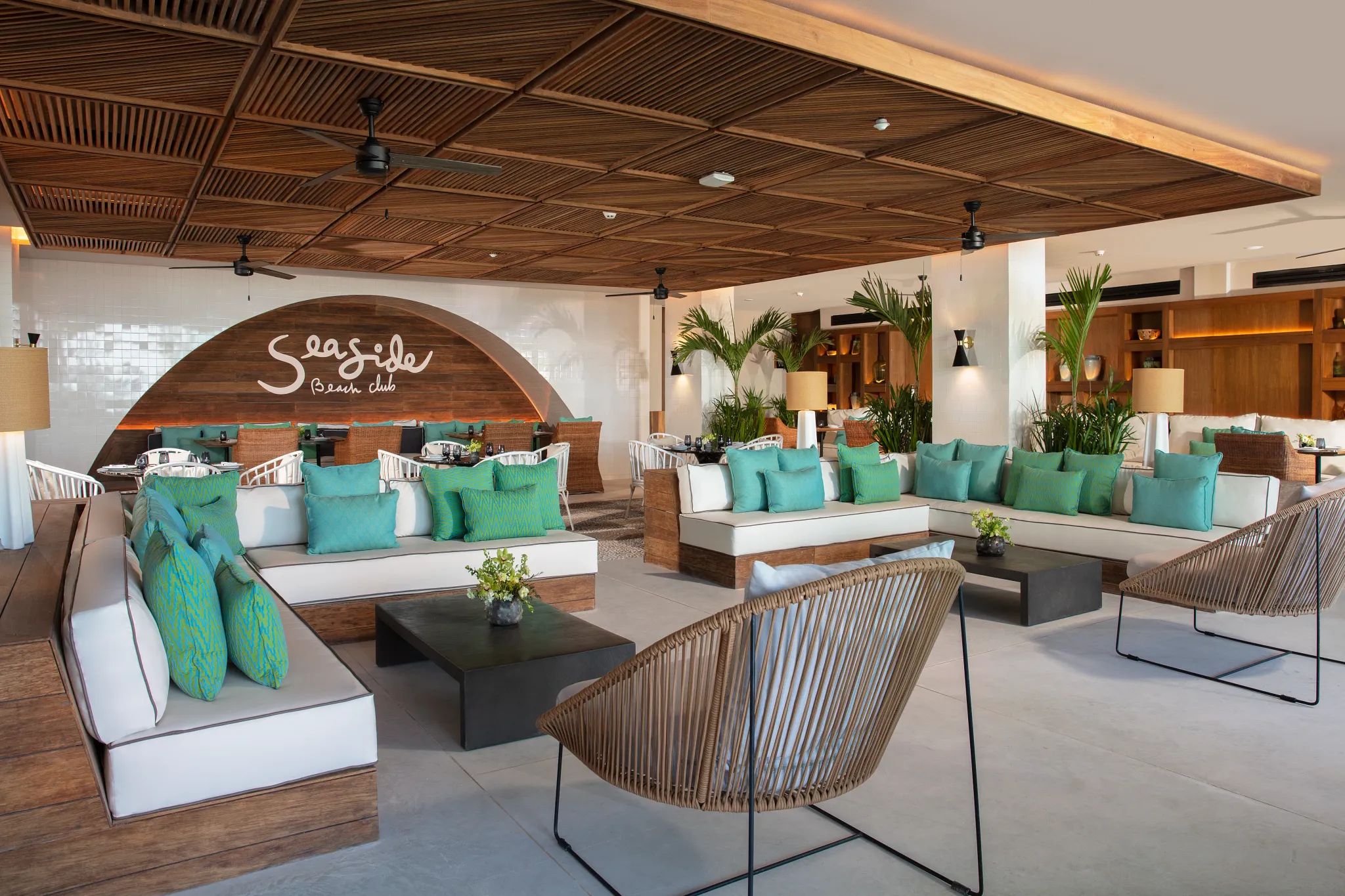 Seaside Beach Club at Impression Moxché by Secrets featuring stylish beachfront lounge seating, turquoise accents, and open-air dining.