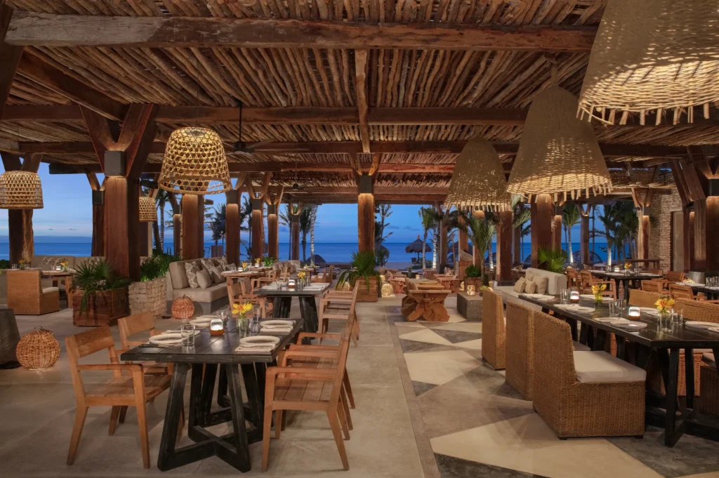 Seasoul oceanfront seafood restaurant at Impression Moxché by Secrets featuring open-air wooden design, woven pendant lighting, and beachfront views.