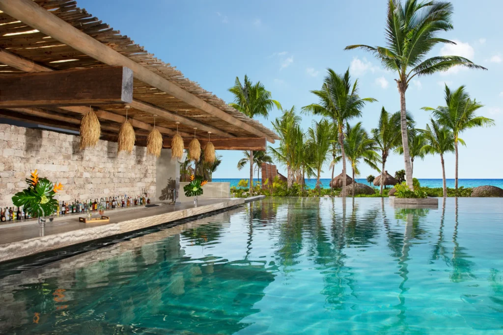 Sugar Reef swim-up bar at Impression Moxché by Secrets featuring infinity pool seating, ocean views, and tropical beachfront setting.