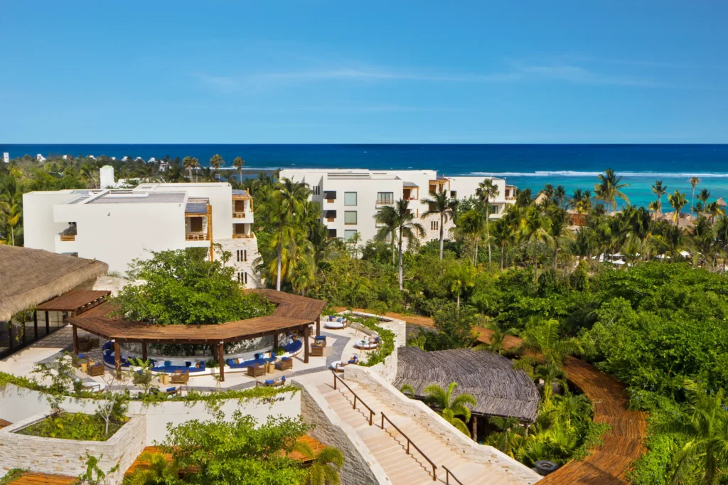 Desires Music Bar Lounge at Secrets Akumal Riviera Maya featuring an open-air rooftop-style terrace, modern lounge seating, and panoramic ocean views at night.