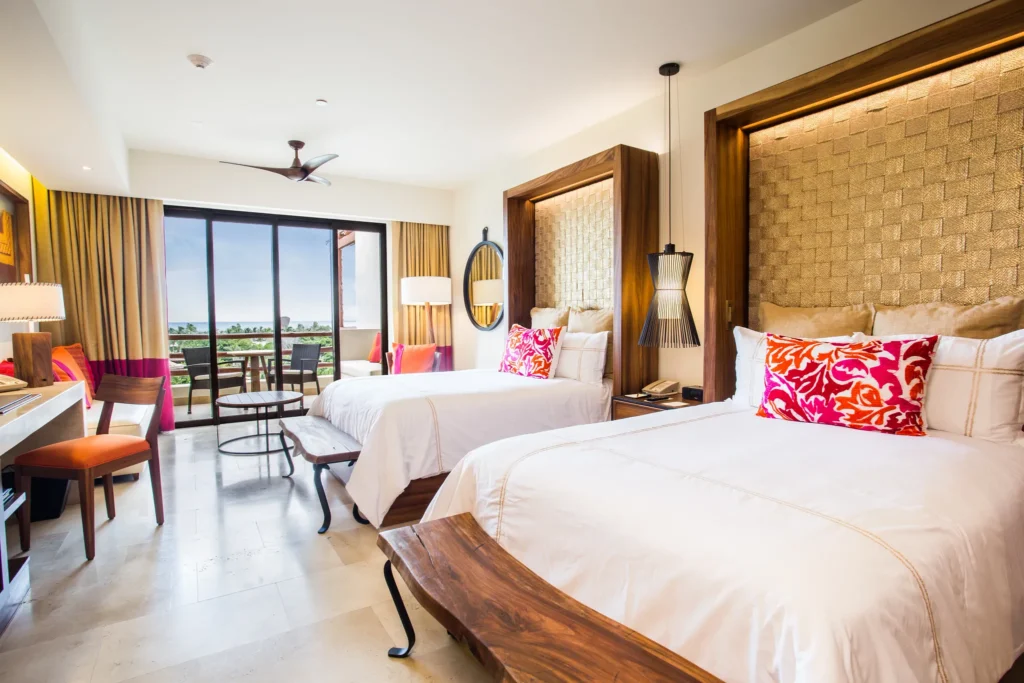 Junior Suite Ocean View with two double beds and private balcony at Secrets Akumal Riviera Maya.