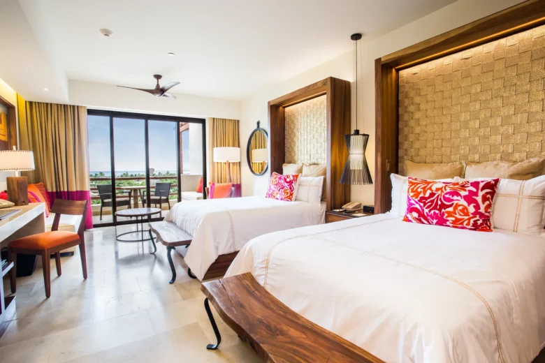 Junior Suite Ocean View with two double beds and private balcony at Secrets Akumal Riviera Maya.