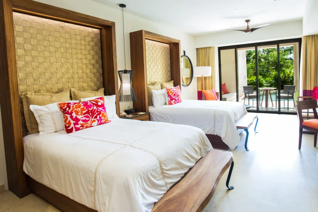Junior Suite Swim Out with two double beds and terrace access at Secrets Akumal Riviera Maya.