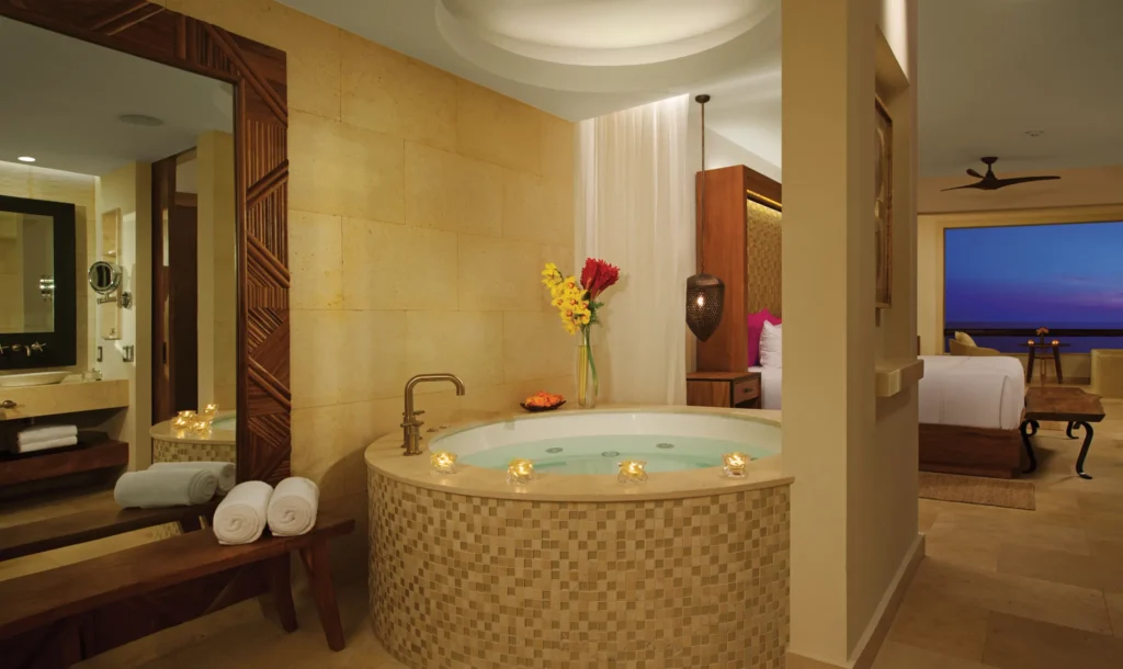 Preferred Club Junior Suite Ocean Front in-room hot tub with candles and luxury décor at Secrets Akumal Riviera Maya.