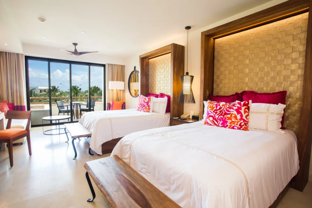 Preferred Club Junior Suite Tropical View with two double beds and private balcony at Secrets Akumal Riviera Maya.