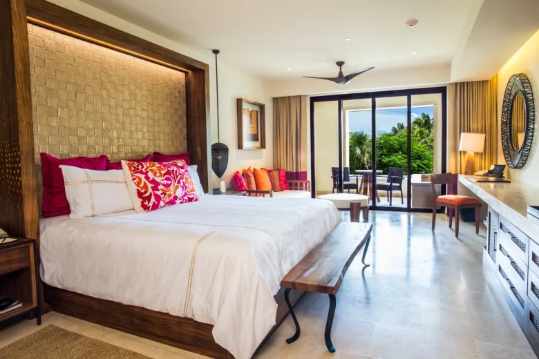Preferred Club Junior Suite Tropical View with king bed and lounge seating at Secrets Akumal Riviera Maya.