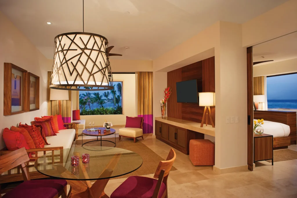 Romance Master Suite Ocean Front living room with sofa, dining area, and ocean views at Secrets Akumal Riviera Maya.