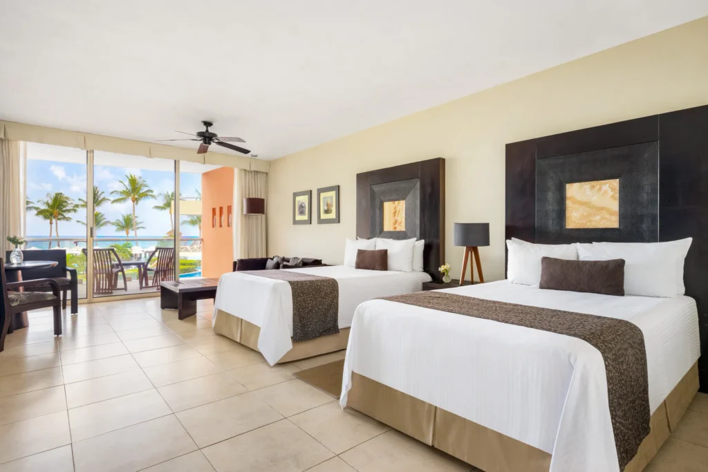 Junior Suite Ocean View with two double beds and balcony at Secrets Aura Cozumel.