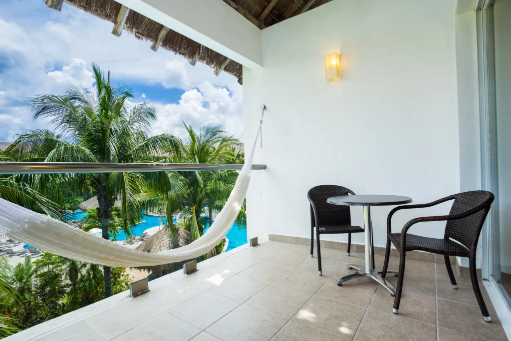 Private balcony with hammock and pool view at Junior Suite Secrets Aura Cozumel.