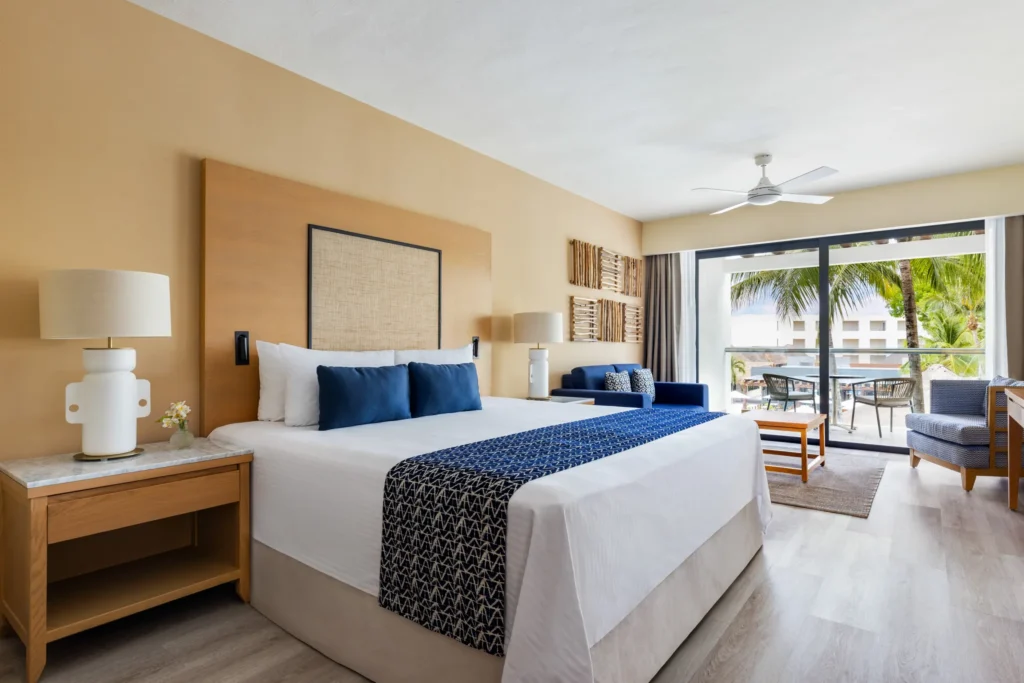 Junior Suite Pool View king bedroom with modern décor at Secrets Aura Cozumel.