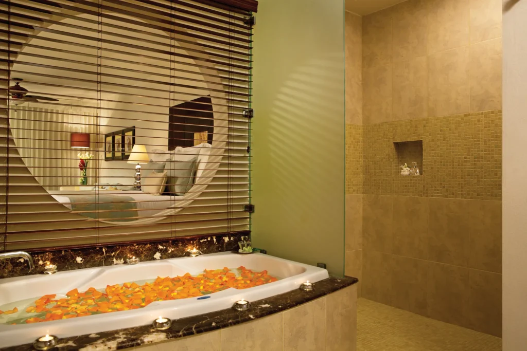 Junior Suite Swim-Up Ocean View bathroom with soaking tub and candle setup at Secrets Aura Cozumel.