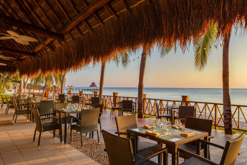 Market Café buffet restaurant at Secrets Aura Cozumel featuring oceanfront dining, international cuisine stations, and a vibrant open-air setting.
