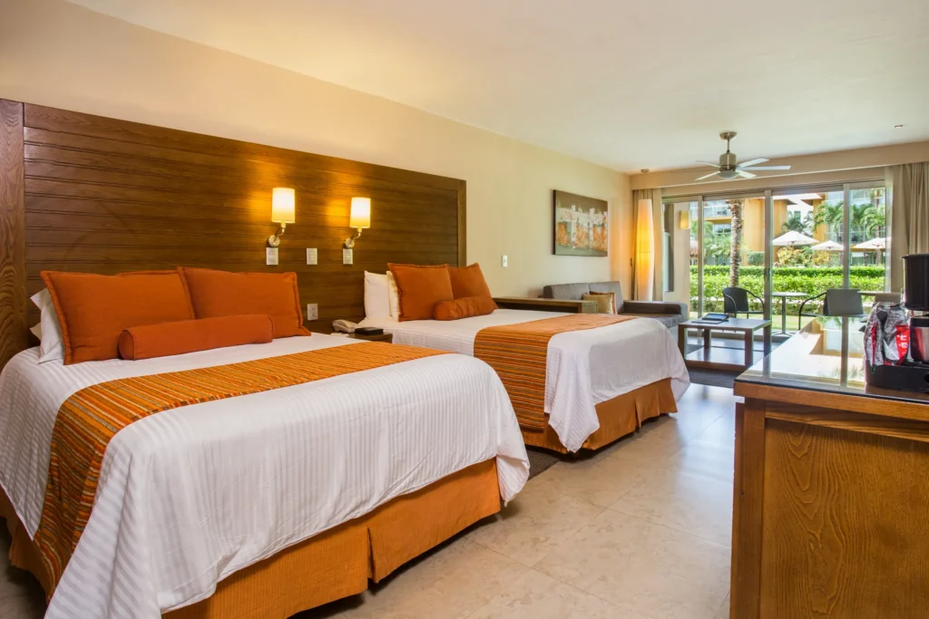 Preferred Club Junior Suite Ocean View with two double beds and garden terrace at Secrets Aura Cozumel.