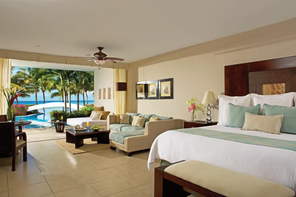 Preferred Club Junior Suite Swim-Up Ocean View interior with king bed and oceanfront terrace at Secrets Aura Cozumel.
