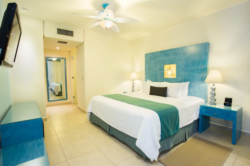 Preferred Club Junior Suite Swim-Up Ocean View bedroom with king bed and modern décor at Secrets Aura Cozumel.