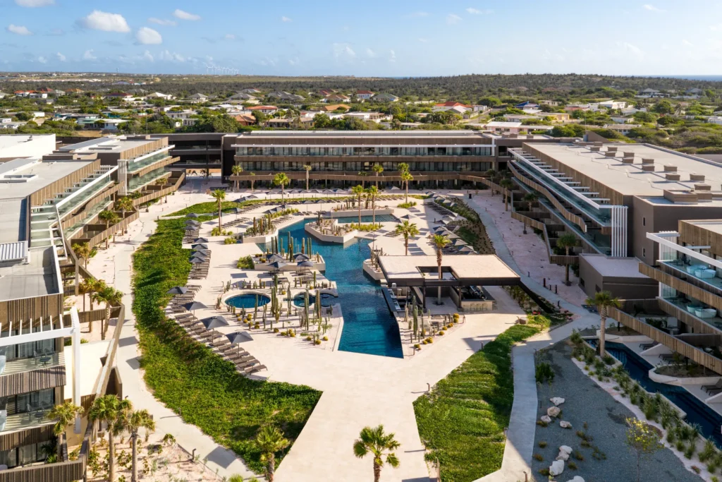 Aerial sunset view of Secrets Baby Beach Aruba overlooking the Caribbean coastline.