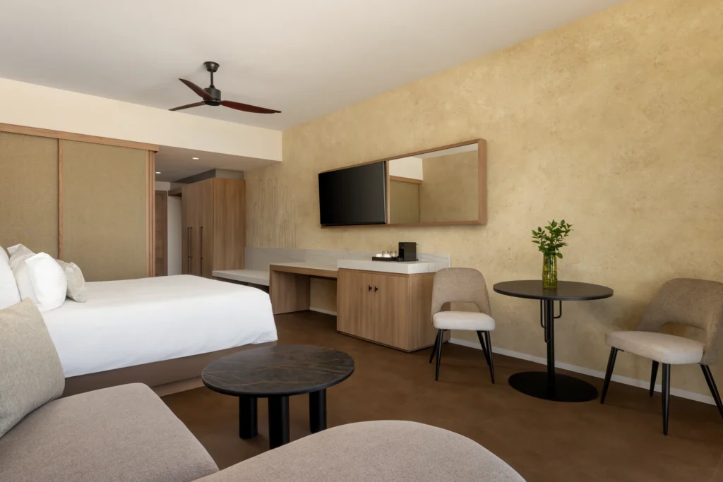 Junior Suite with king-size bed and private furnished terrace at Secrets Baby Beach Aruba.