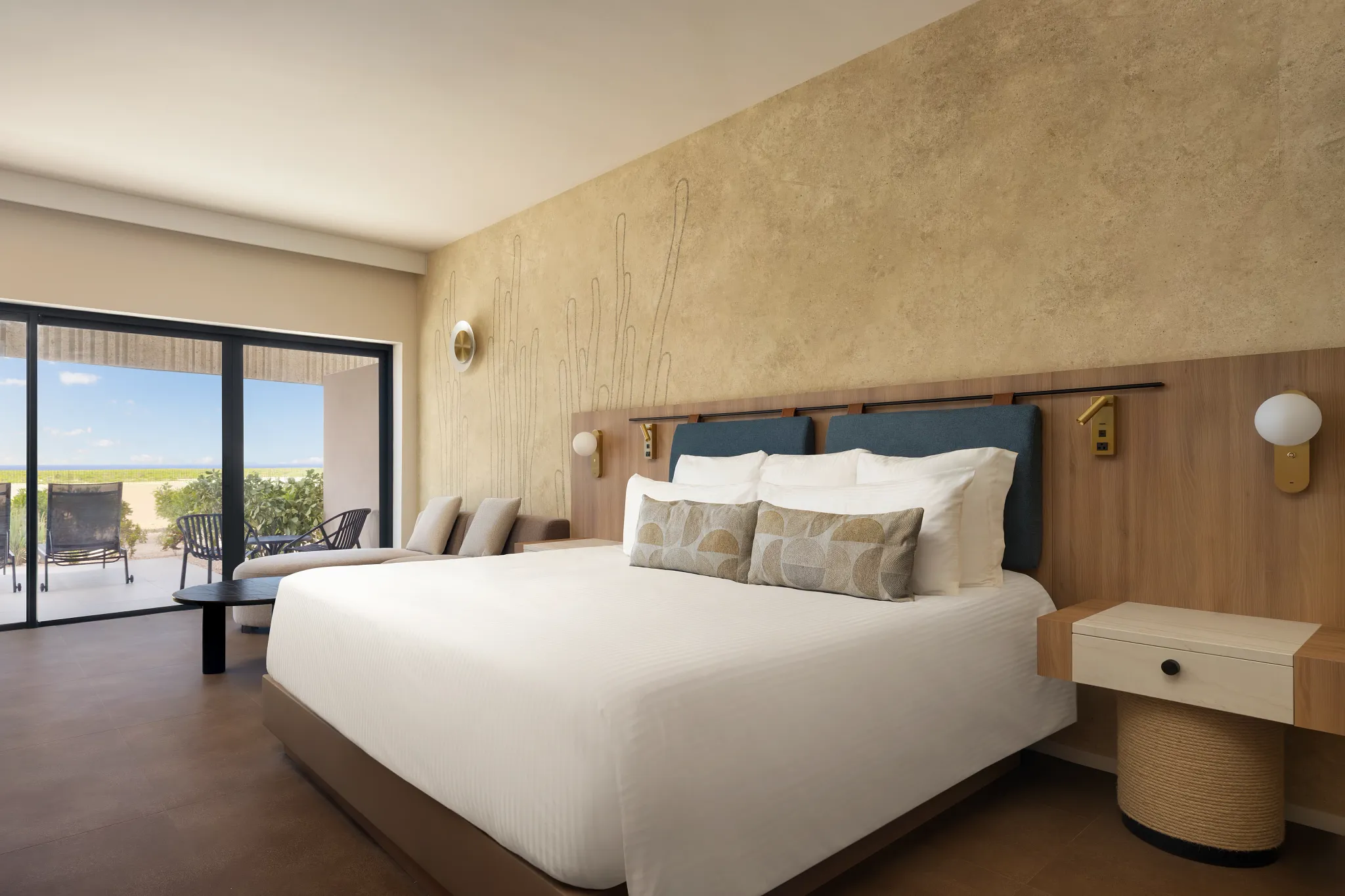 Junior Suite king bedroom with seating area and balcony at Secrets Baby Beach Aruba.