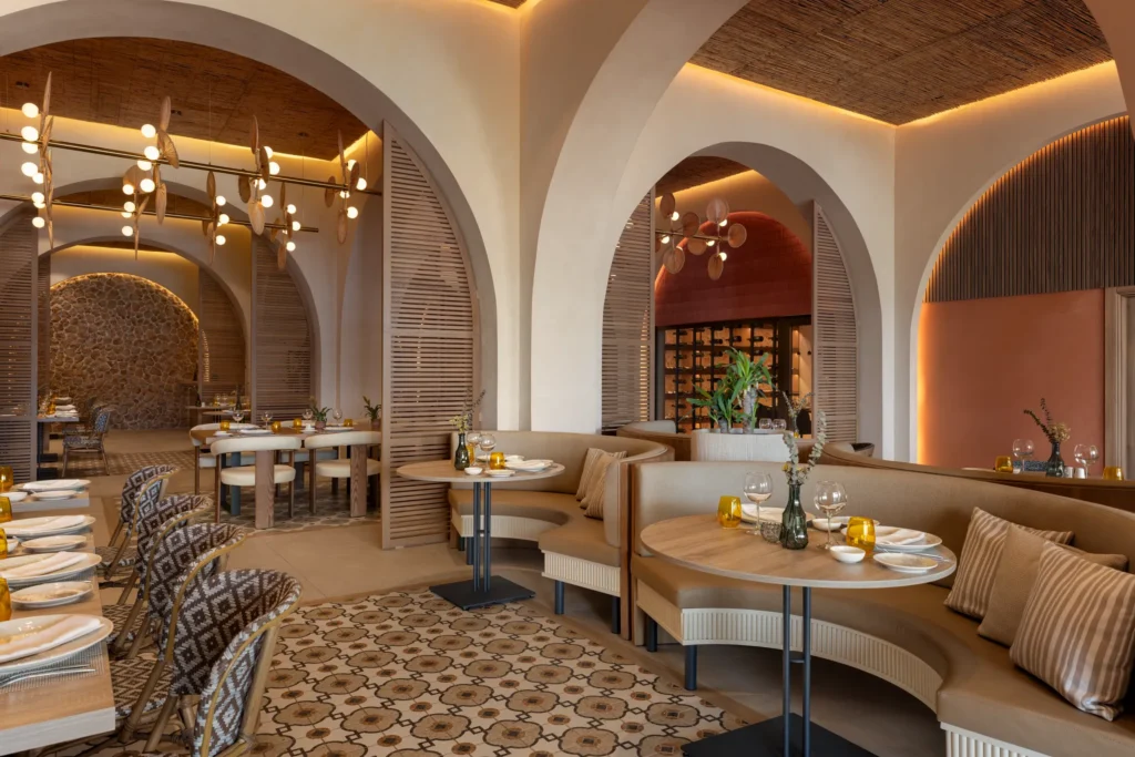 Portofino Italian restaurant at Secrets Baby Beach Aruba featuring elegant arched architecture, warm lighting, and intimate dining booths.