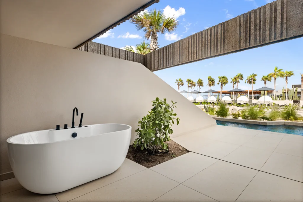 Preferred Club Junior Suite Swim Out terrace with outdoor soaking tub and direct pool access at Secrets Baby Beach Aruba.