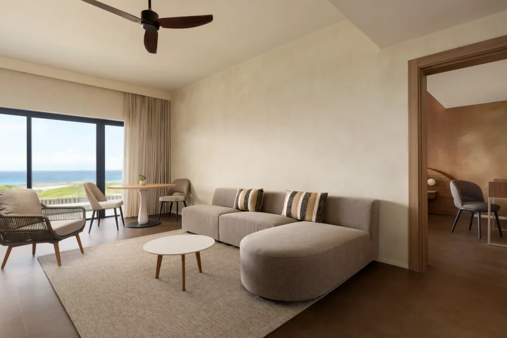 Preferred Club Master Suite Ocean View living area with sofa and dining space at Secrets Baby Beach Aruba.