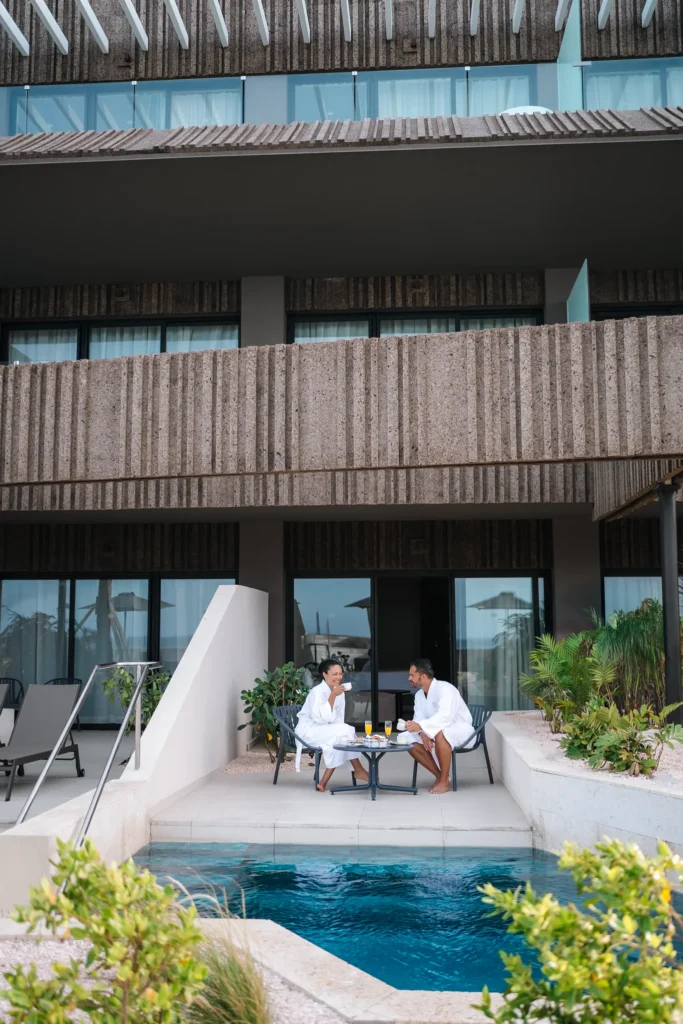 Couple enjoying breakfast by a private pool terrace at Secrets Baby Beach Aruba.