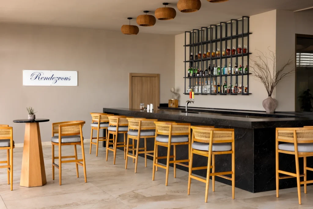 Rendezvous Lobby Bar at Secrets Baby Beach Aruba featuring elegant bar seating, premium spirits display, and relaxed lounge atmosphere.