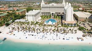 Riu Palace Aruba all-inclusive resort on Palm Beach with beachfront pools, high-rise towers, and vibrant Caribbean atmosphere.
