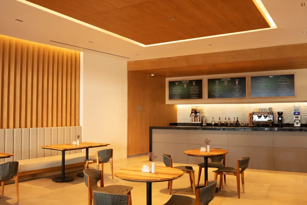 Coco Café & Gelato at Secrets Bahia Mita Surf & Spa Resort featuring a modern coffee bar with warm wood accents, cozy seating, and freshly made pastries and gelato.