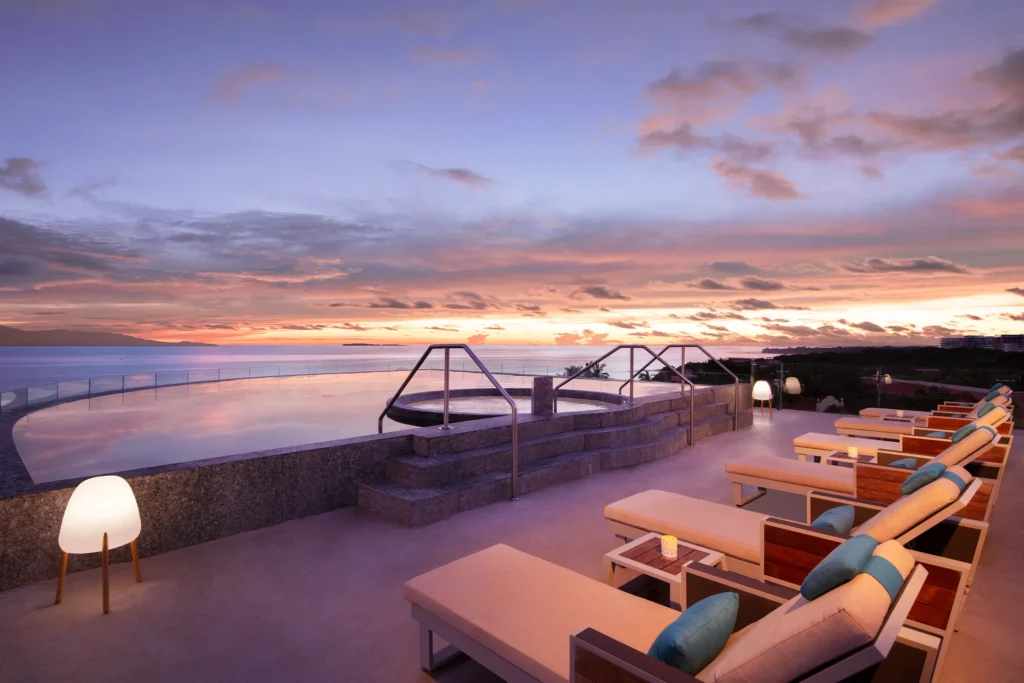 Sunset view of the Marietas pool with loungers at Secrets Bahia Mita Surf & Spa Resort.