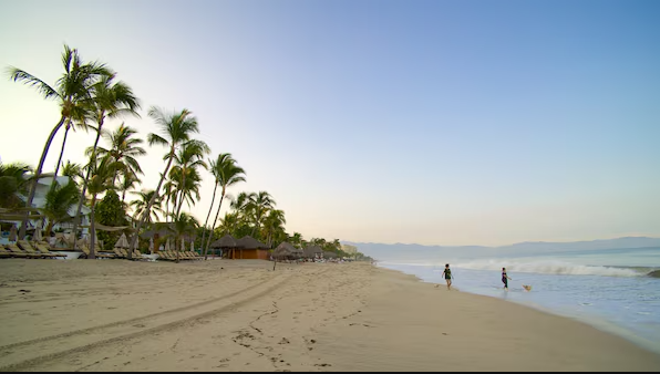 Nuevo Vallarta Beach near Secrets Bahia Mita Surf & Spa Resort with wide sandy shoreline, palm trees, and calm ocean views