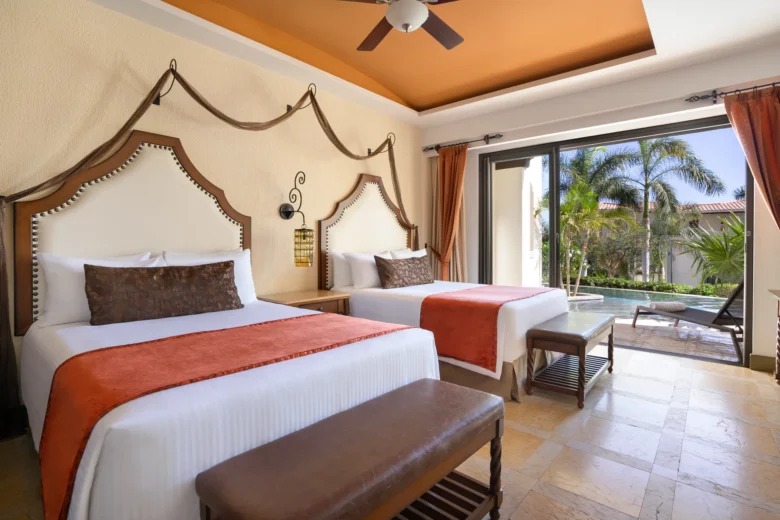 Junior Suite Swim Out Garden View with double beds and private terrace leading to pool at Secrets Puerto Los Cabos.
