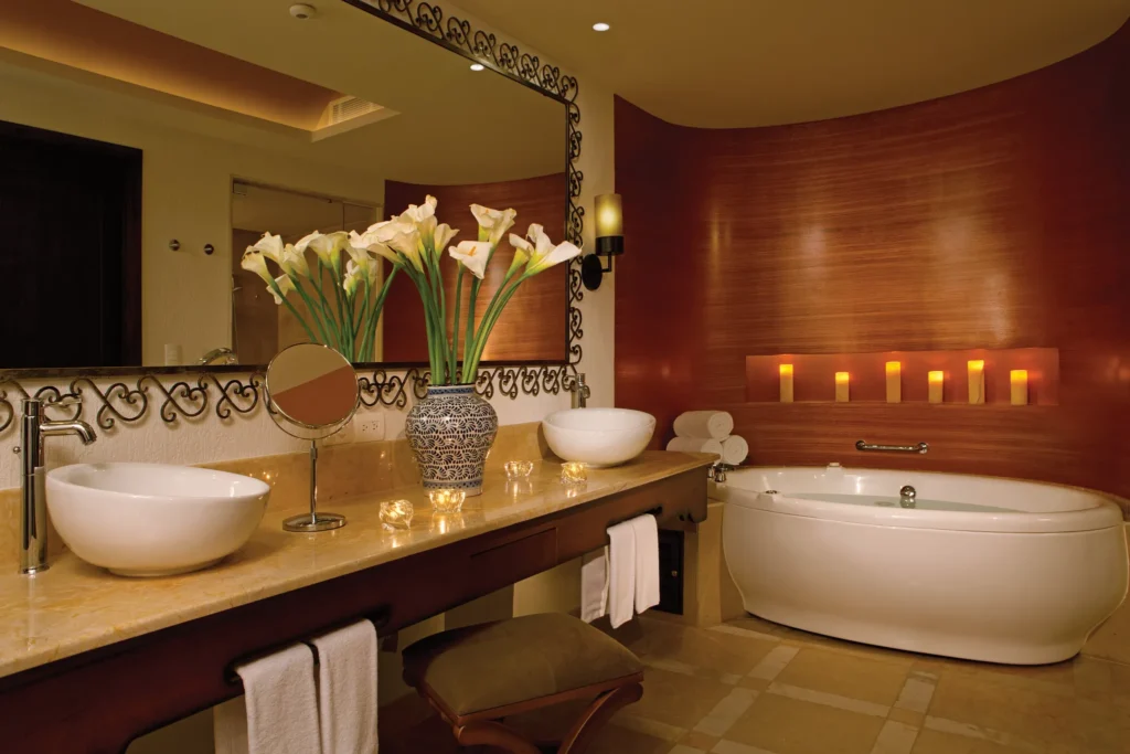 Master Suite Ocean Front bathroom with dual sinks, soaking tub, and candle accents at Secrets Puerto Los Cabos Golf & Spa Resort.