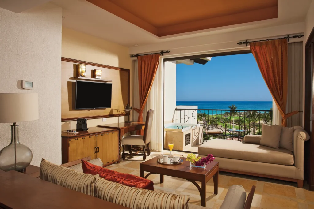 Master Suite Ocean View living area with sofa and ocean-view terrace at Secrets Puerto Los Cabos.