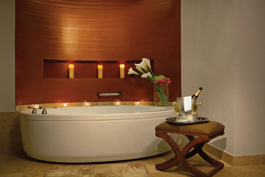 Presidential Suite Swim Out bathroom with soaking tub and candle accents at Secrets Puerto Los Cabos Golf & Spa Resort.
