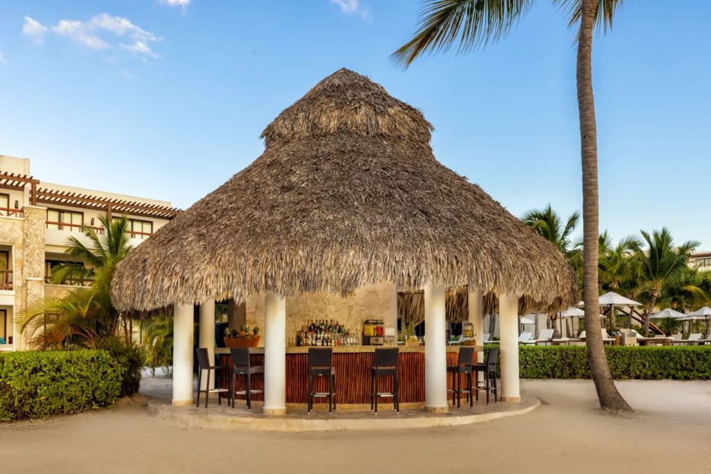 Barracuda swim-up bar at Secrets Cap Cana Resort & Spa featuring refreshing cocktails, poolside seating, and stunning Caribbean views.