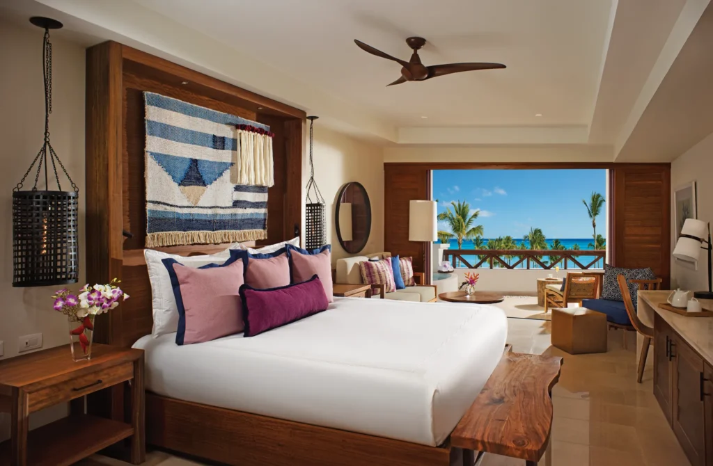 Junior Suite King Bed with furnished balcony and resort views at Secrets Cap Cana Resort & Spa.