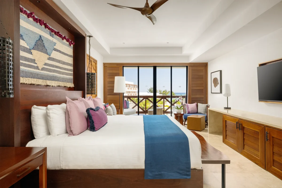 Junior Suite Ocean View with king bed and furnished balcony overlooking the ocean at Secrets Cap Cana Resort & Spa.