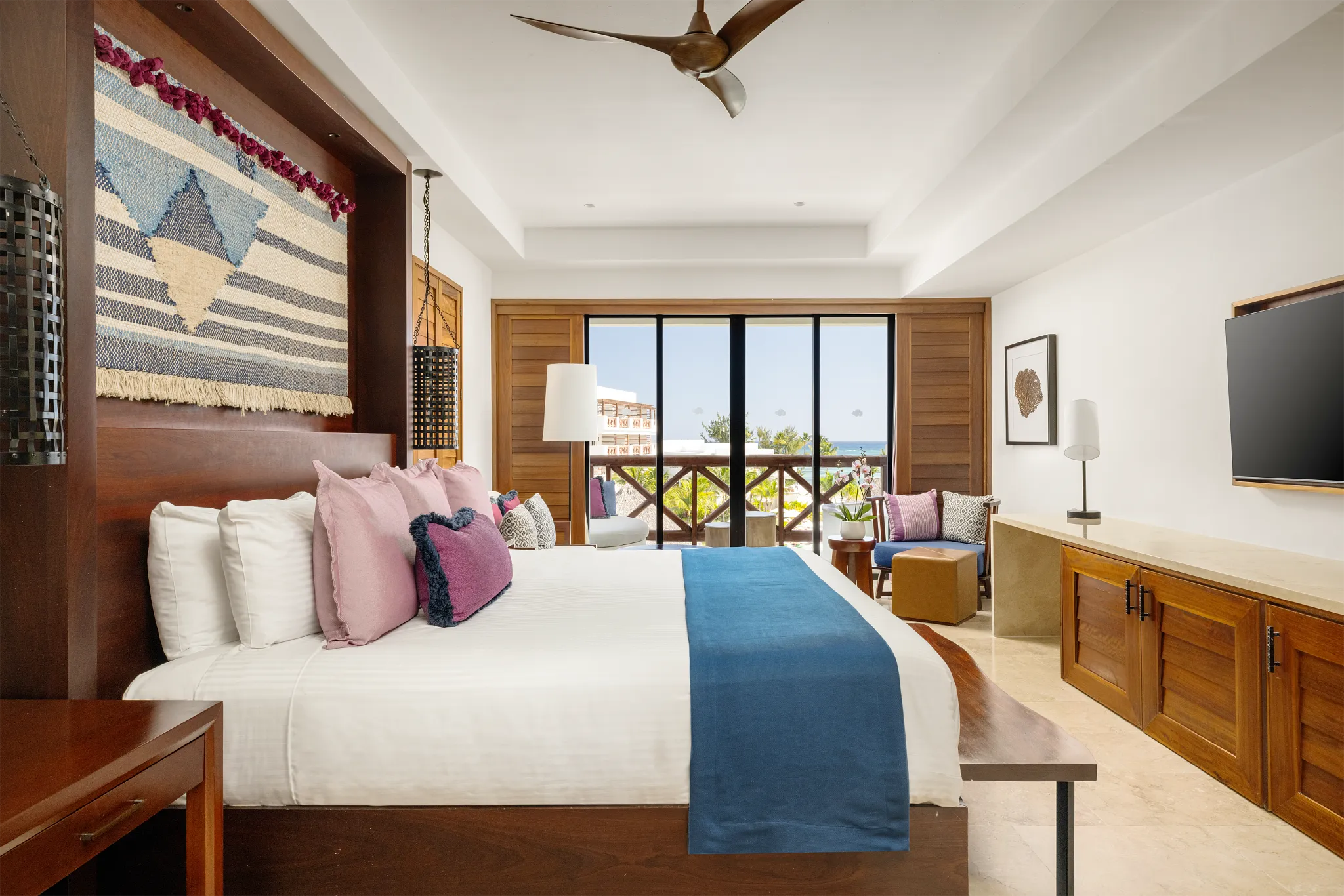 Junior Suite Ocean View with king bed and furnished balcony overlooking the ocean at Secrets Cap Cana Resort & Spa.