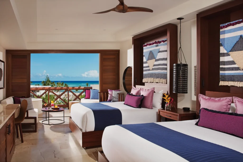 Junior Suite Ocean View with two double beds and private balcony at Secrets Cap Cana Resort & Spa.