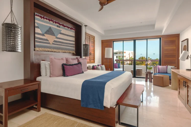 Junior Suite Partial Ocean View with king bed and furnished balcony at Secrets Cap Cana Resort & Spa.