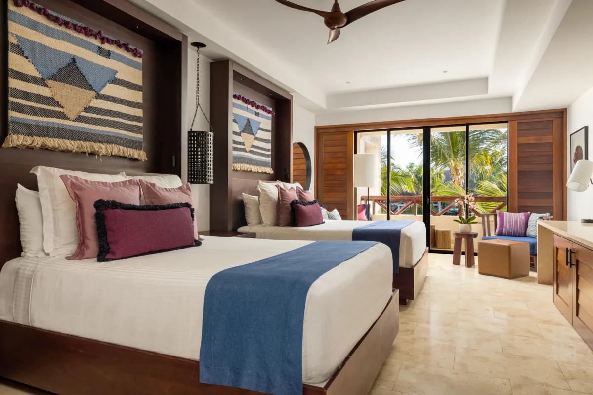 Junior Suite Pool View with two double beds and private balcony at Secrets Cap Cana Resort & Spa.