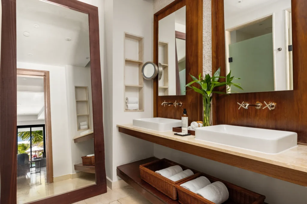 Junior Suite Swim Out bathroom with dual sinks, large mirrors, and luxury amenities at Secrets Cap Cana Resort & Spa.