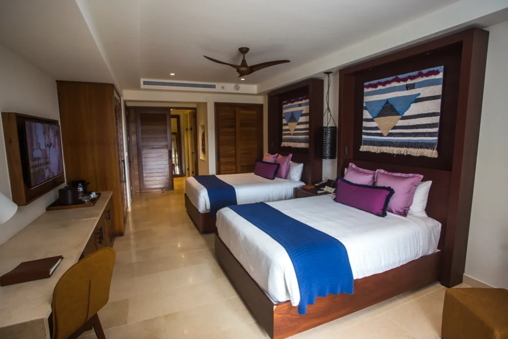 Preferred Club Junior Suite Swim Out Pool View with two double beds, spacious interior, and direct pool access at Secrets Cap Cana Resort & Spa.