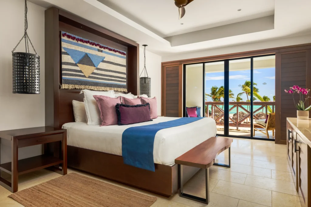 Preferred Club Master Suite Ocean Front bedroom with king-size bed, oceanfront balcony, and Caribbean-inspired luxury décor.