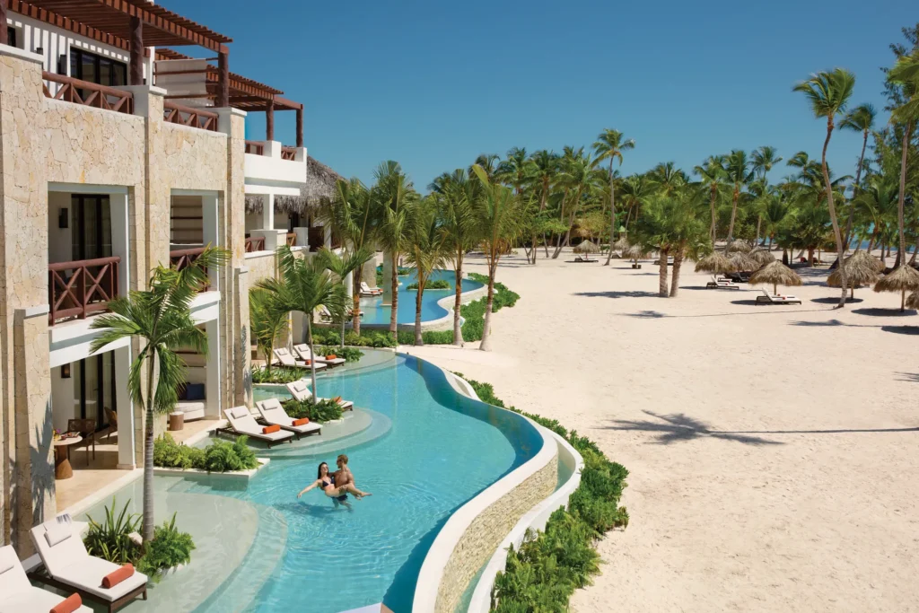 Oceanfront swim-out suites with direct pool access, tropical landscaping, and white-sand beach views at Secrets Cap Cana.