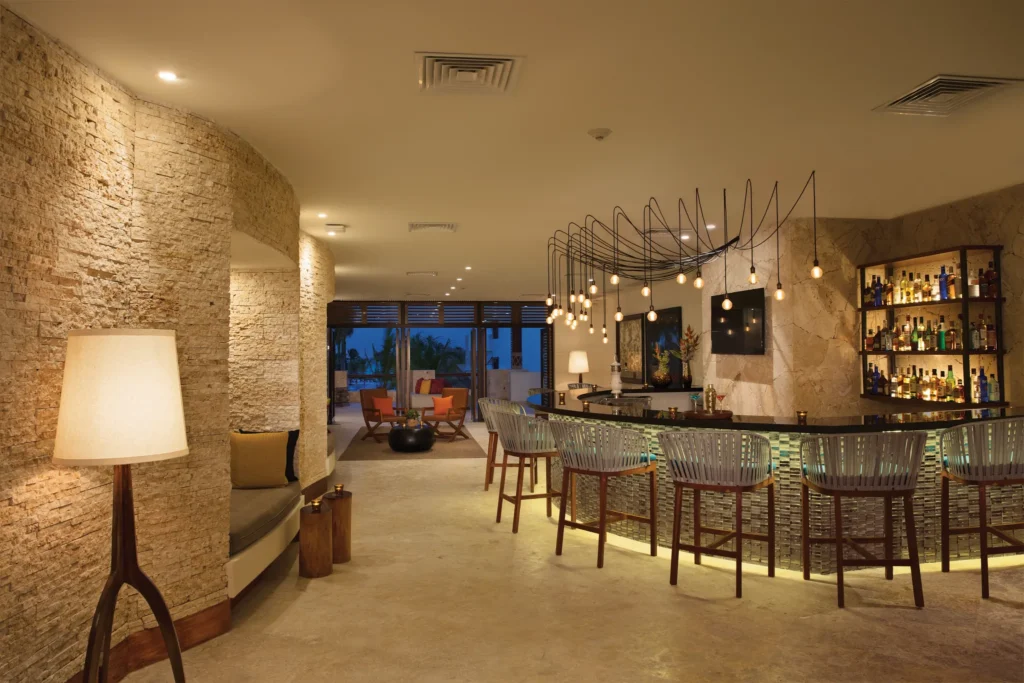 Rendezvous lobby bar at Secrets Cap Cana Resort & Spa featuring elegant lounge seating, handcrafted cocktails, and a sophisticated social atmosphere.